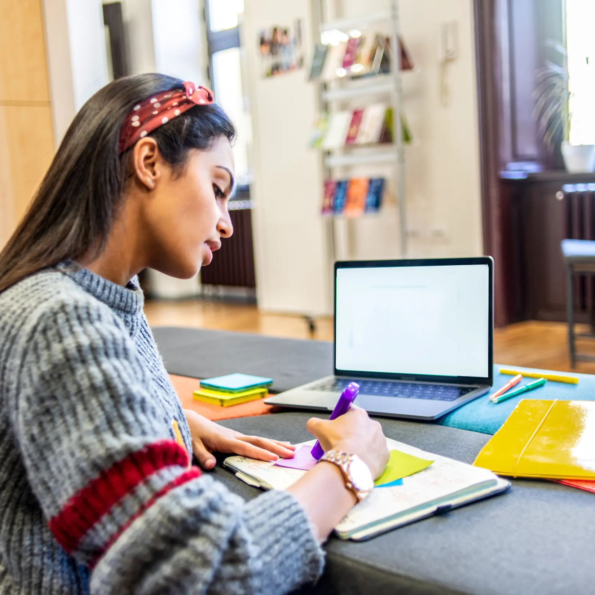 Estudante organizando anotações ao lado do notebook